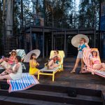 The ensemble cast lounging on beach chairs