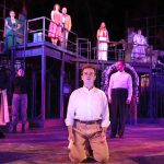 Will Block on his knees in front of the ensemble cast