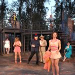 Allie Pratt standing in front of the ensemble cast
